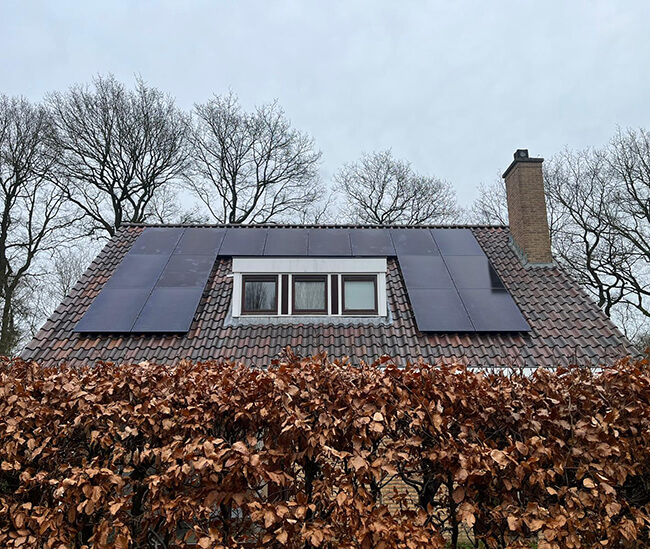 Schuin dak en schoorsteen met zonnepanelen installatie Stadskanaal 
