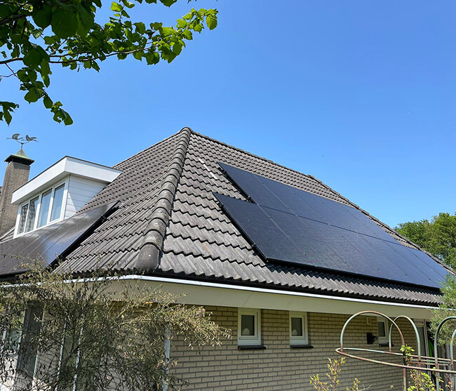 Zwarte zonnepanelen op vrijstaande woning met schuin dak